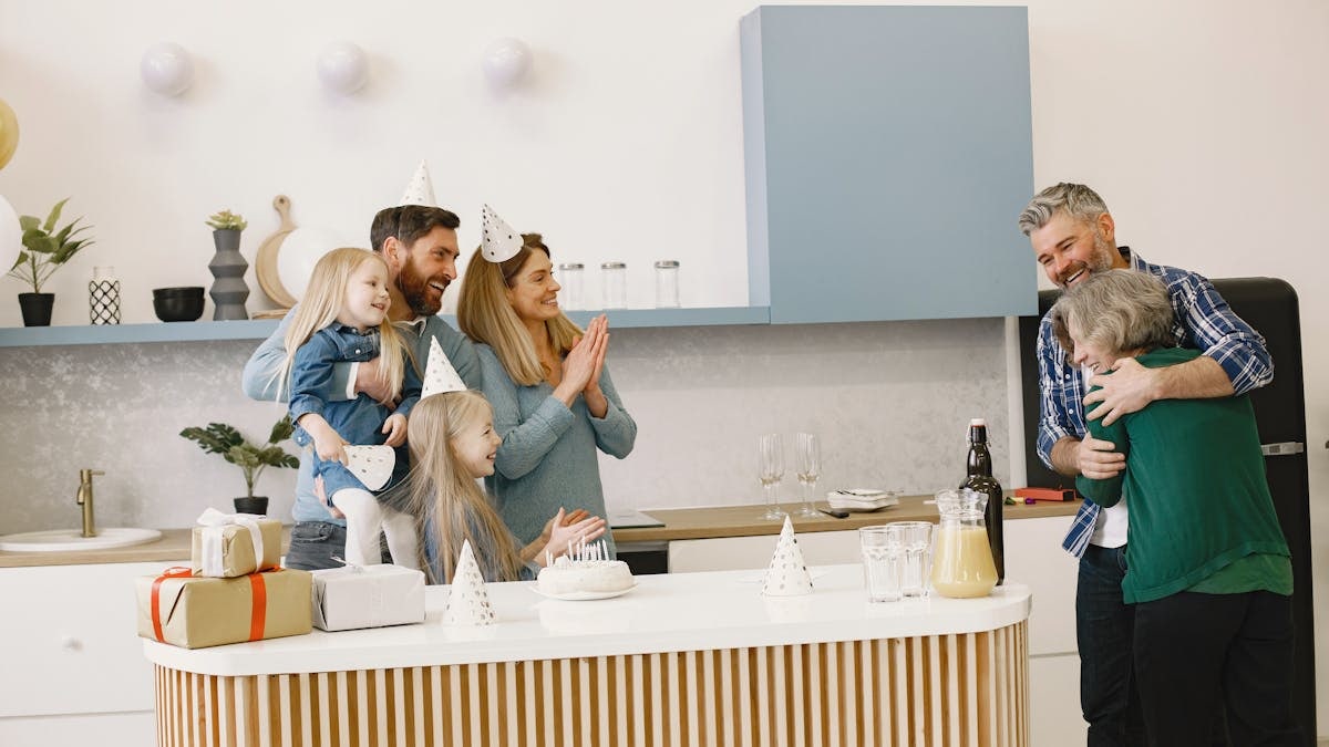 Family celebrating in a modern kitchen with cake, gifts, and happiness. Perfect for family and party themes.